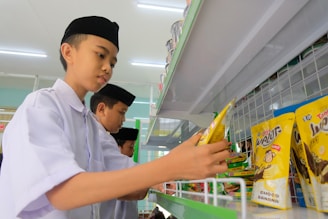 a boy is looking at a bag of potato chips