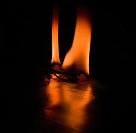 A mystical scene with warm red, orange, and yellow flames surrounding a couple holding hands, symbolizing passion and healing.