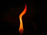A solemn memorial flame flickering against a dark background symbolizing remembrance.