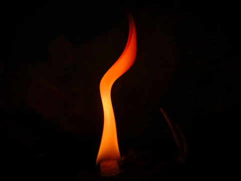 A solemn memorial flame flickering against a dark background symbolizing remembrance.