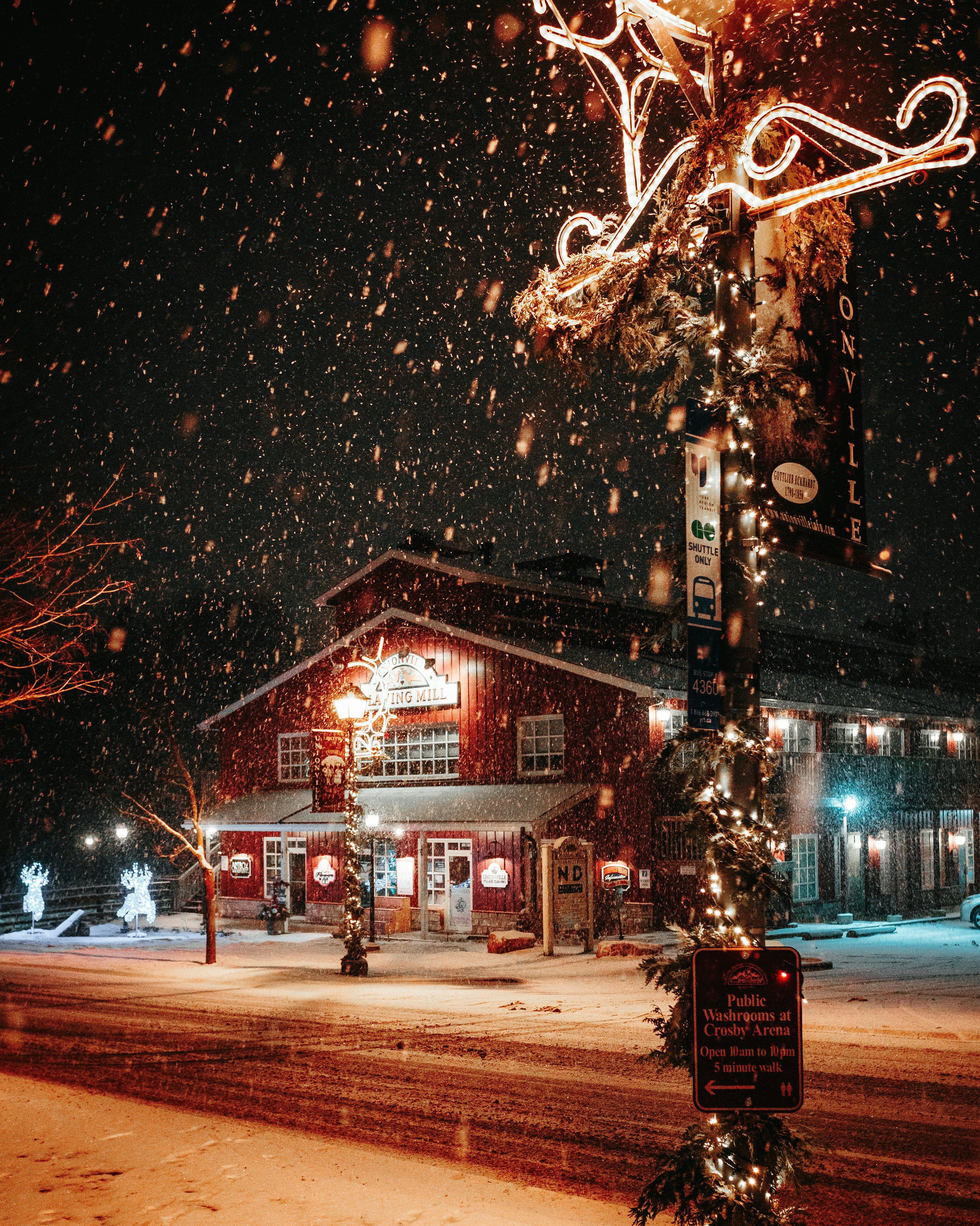 a street light covered in snow next to a building