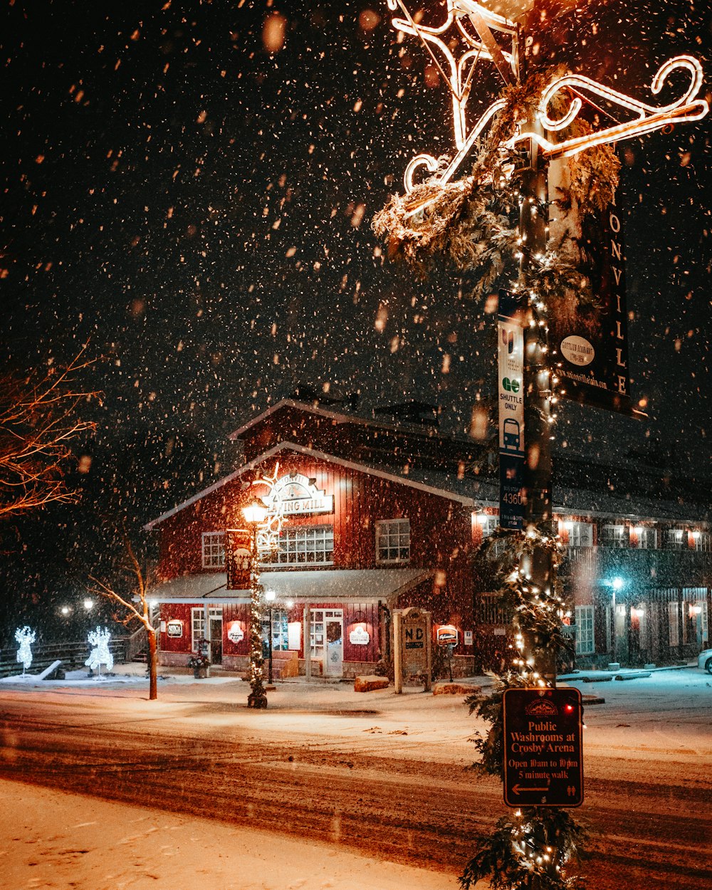 a street light covered in snow next to a building