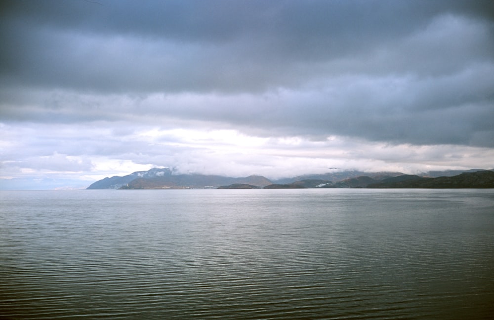 a large body of water under a cloudy sky