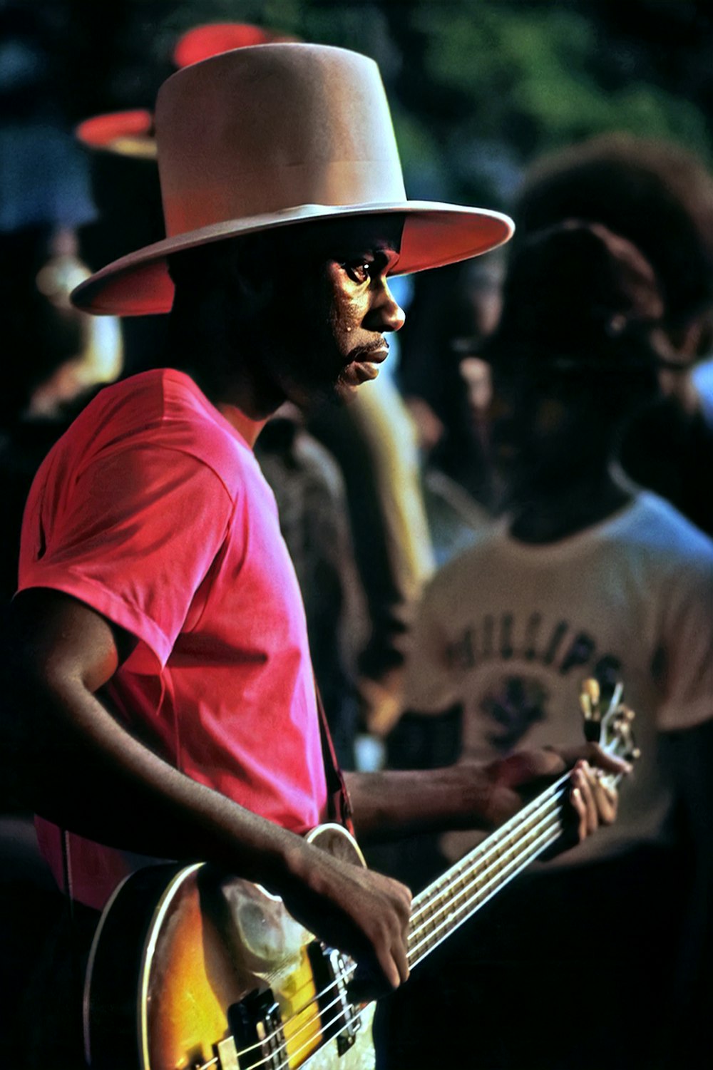 a man with a hat playing a guitar