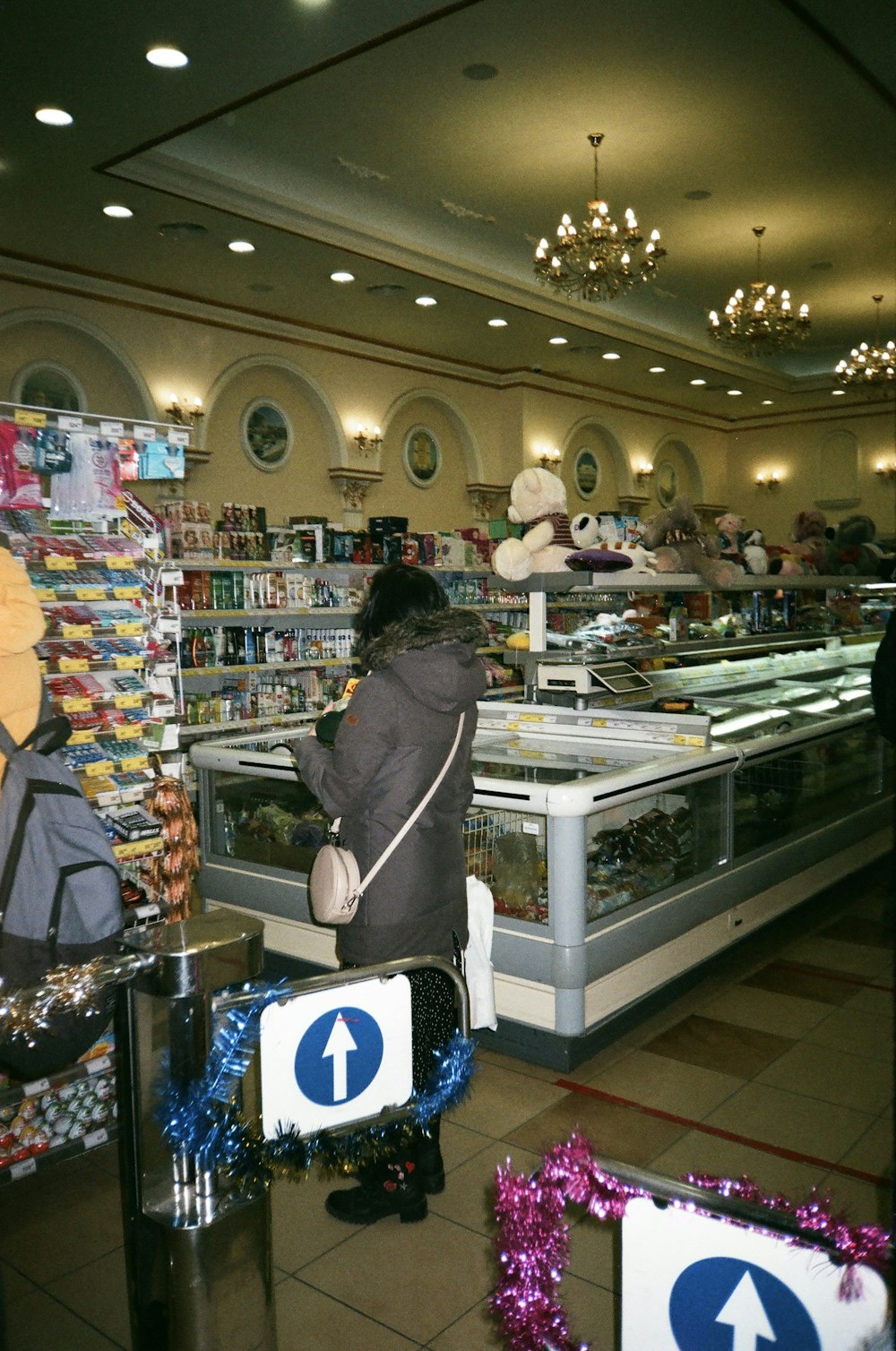 a woman standing in front of a store filled with items