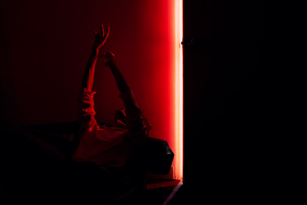 a person reaching up into the air in a dark room