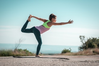 a woman doing a yoga pose on a beach