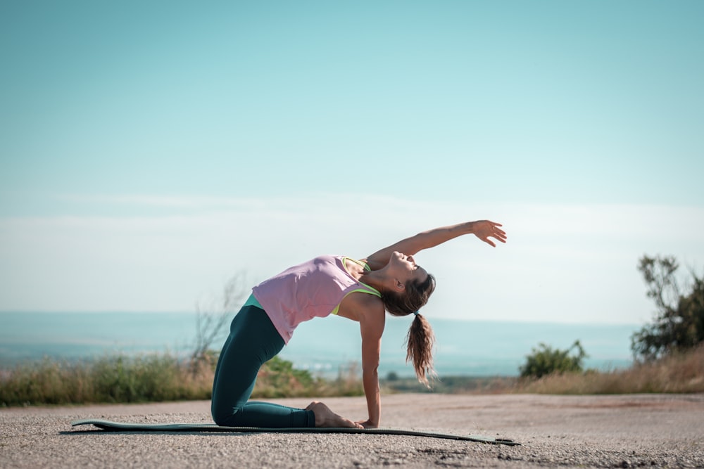 a woman doing a yoga pose on a yoga mat