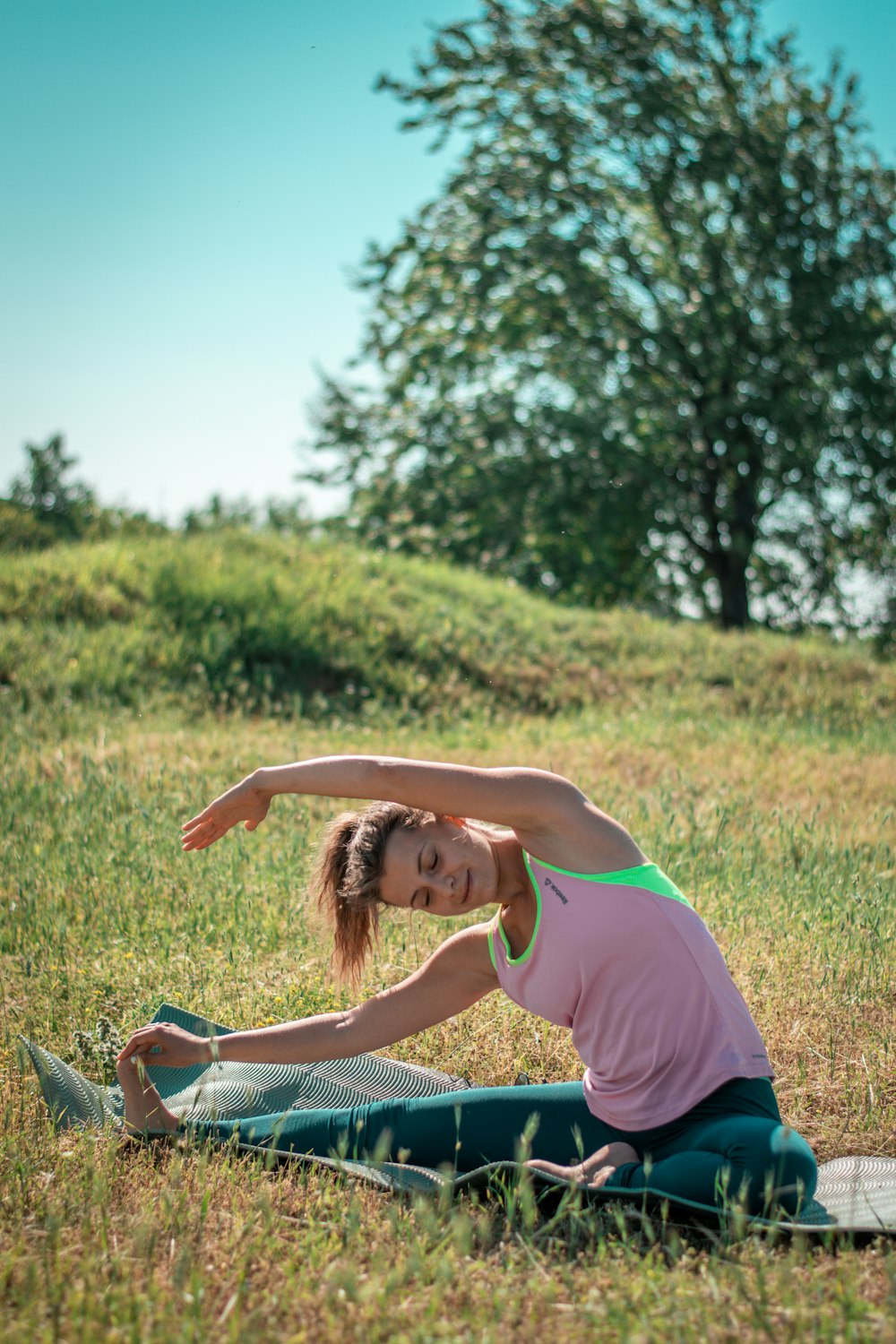 Una mujer haciendo una pose de yoga en un campo