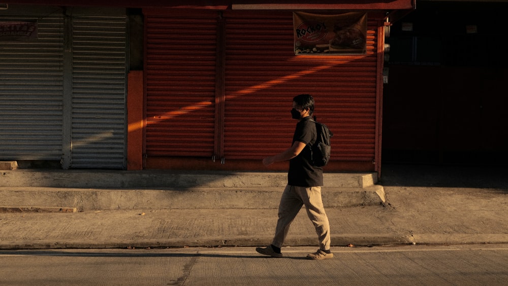 Un hombre caminando por la calle frente a una tienda