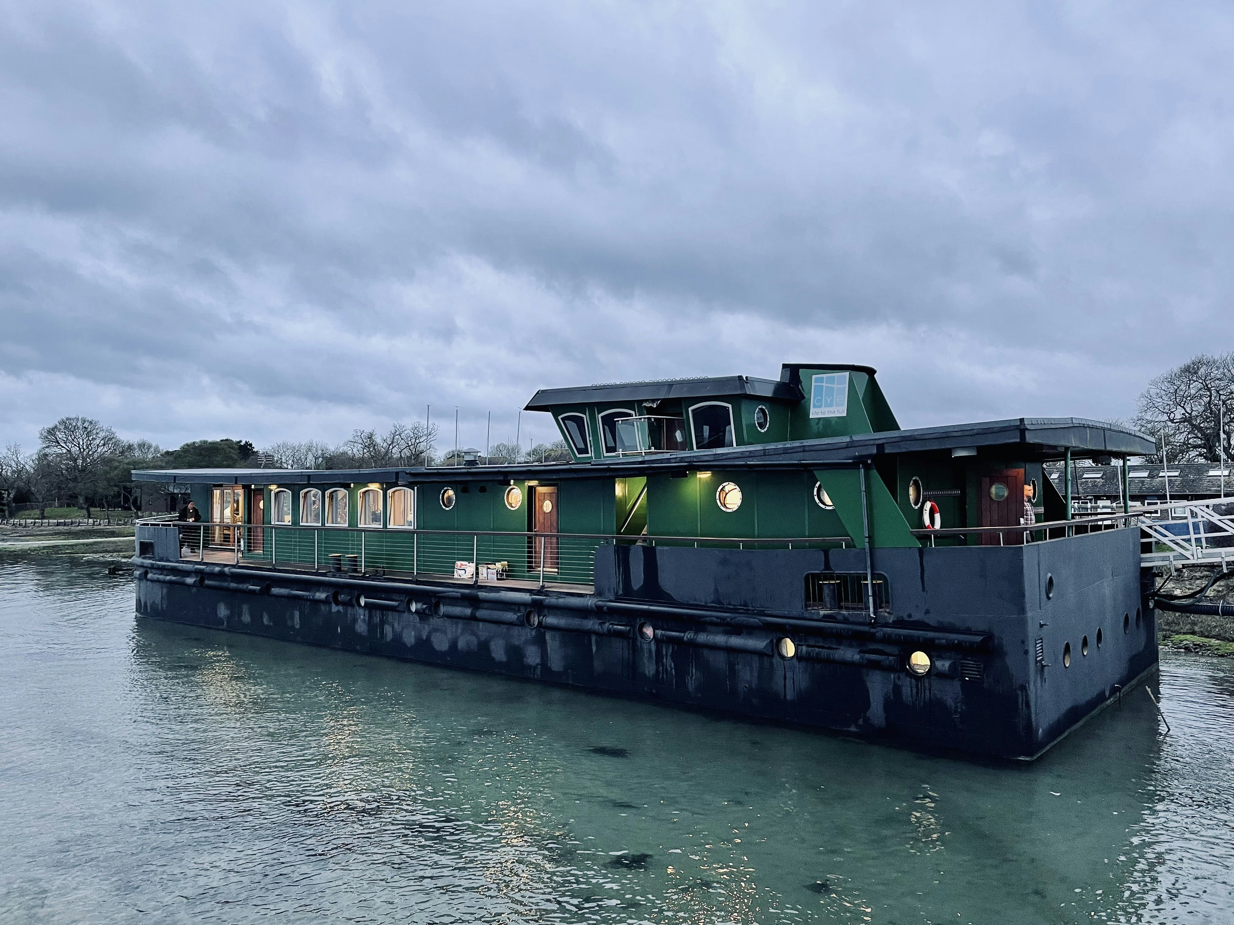 A green and black boat floating on top of a body of water