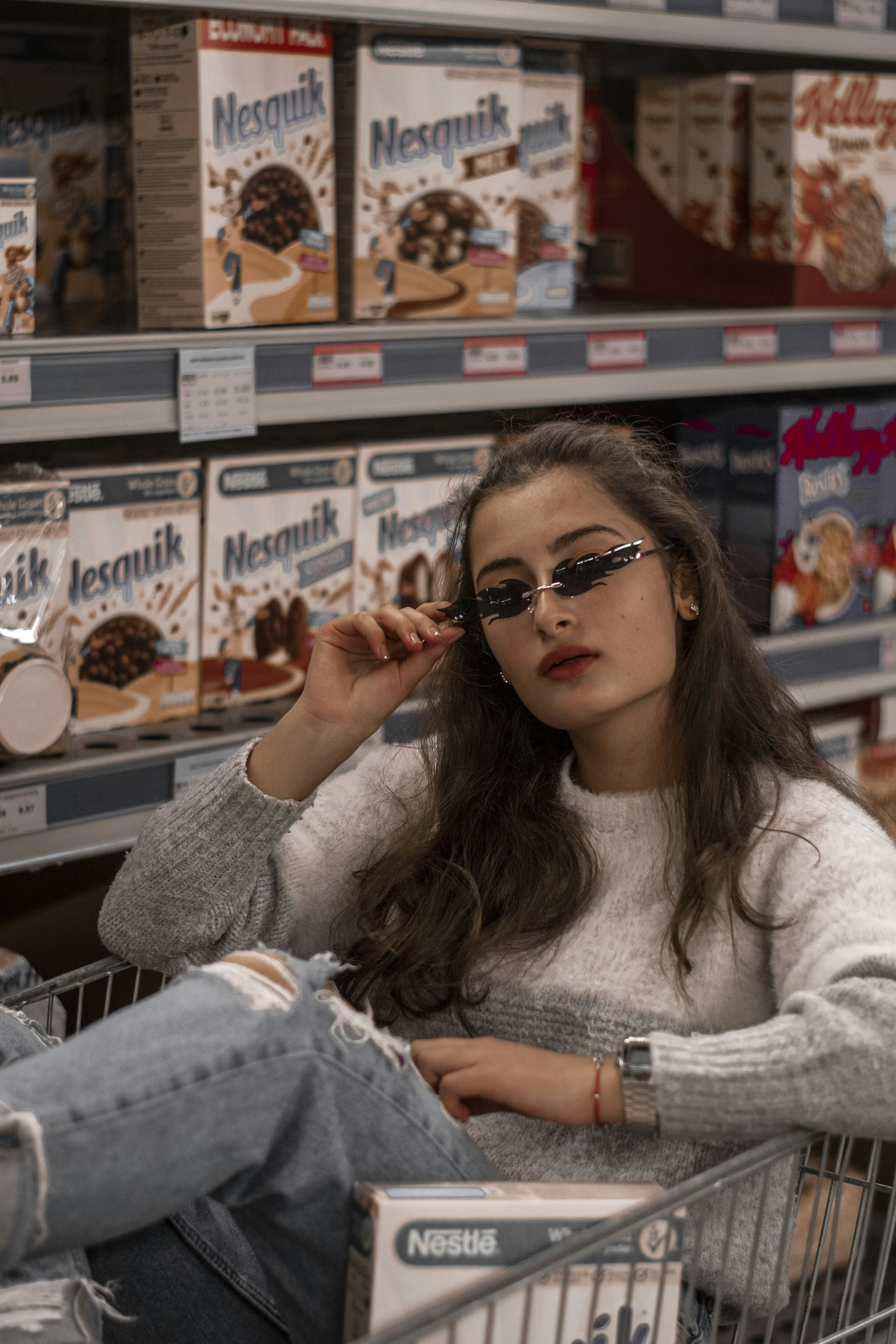 uma mulher sentada em um carrinho de compras em uma loja