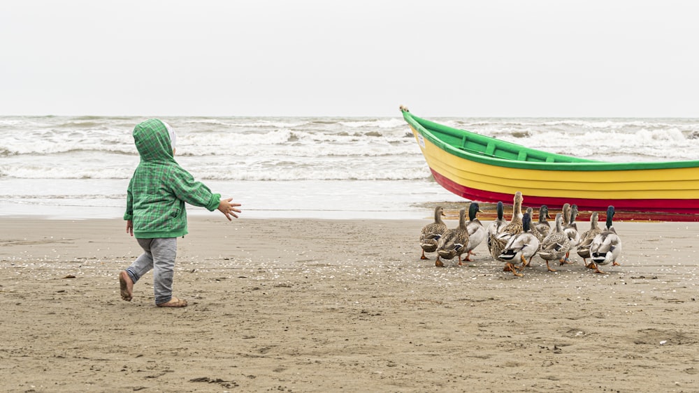 a person walking on a beach near a boat