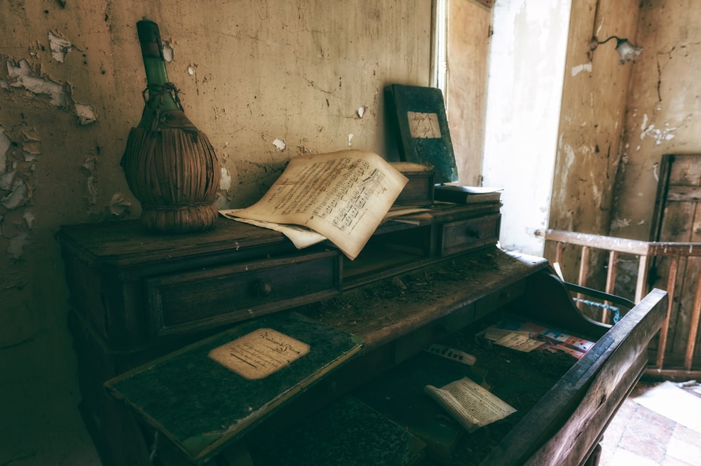 uma mesa velha com um livro e um vaso em cima dele