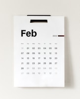 A wall calendar displays the month of February 2022. The days of the week are listed across the top, with individual dates arranged in a grid below. The overall design is simple and minimalistic.