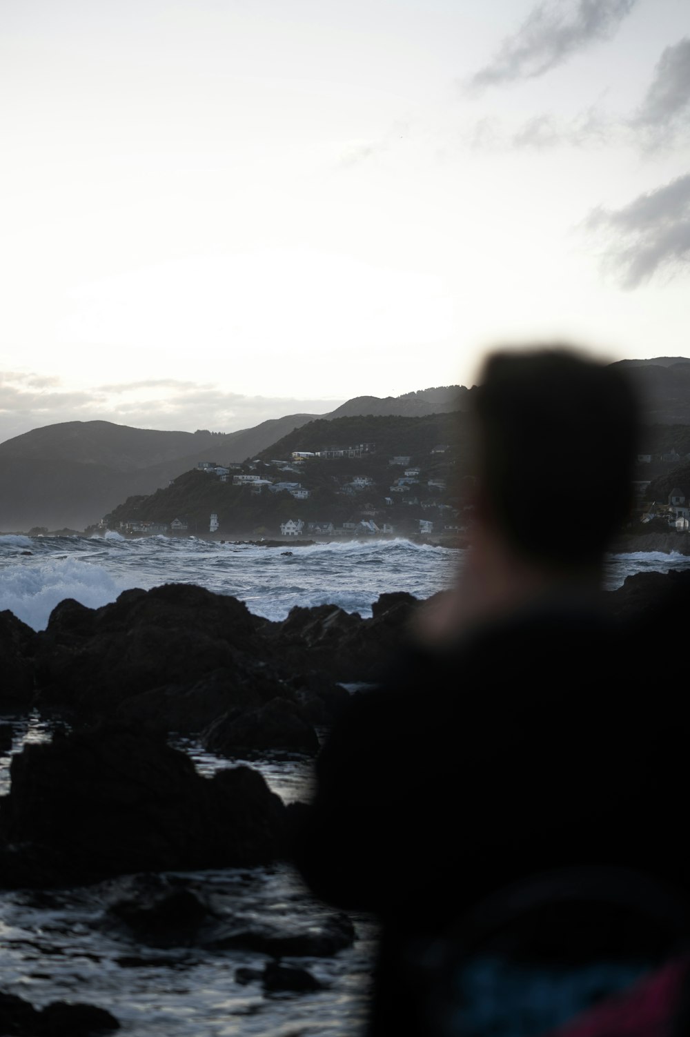 a man standing next to the ocean with a surfboard