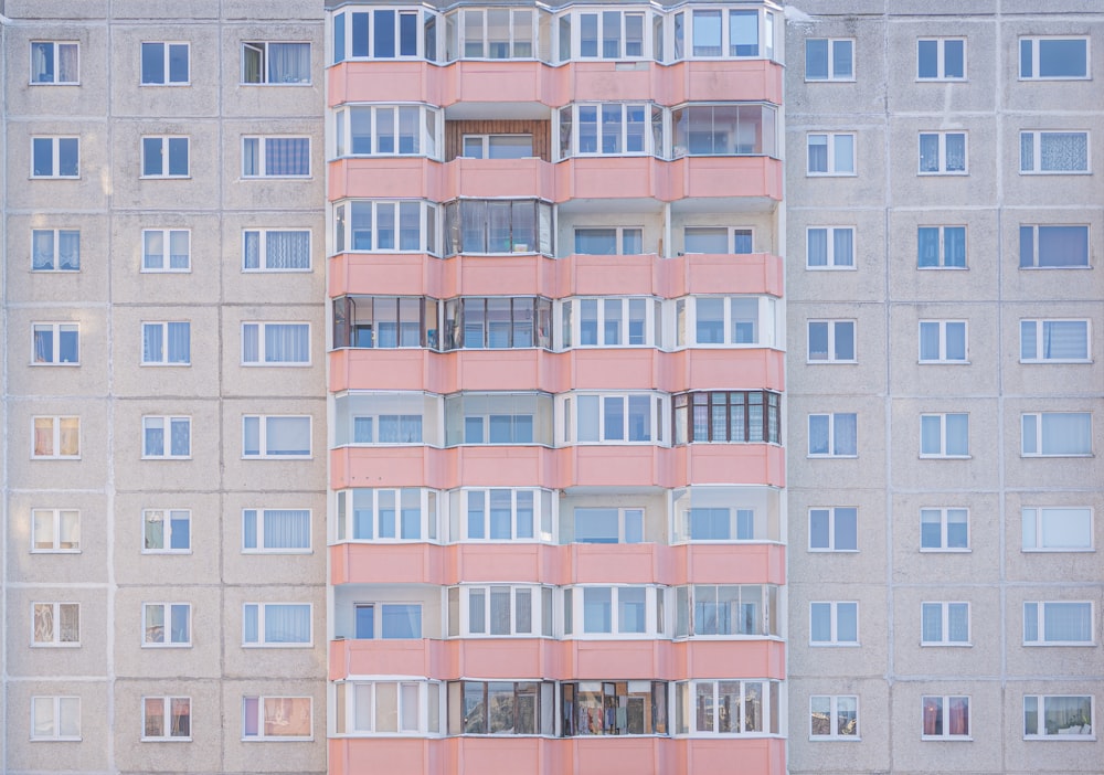 a tall pink building with lots of windows
