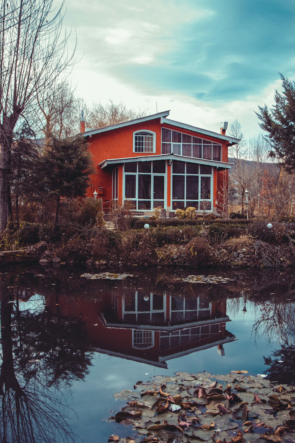 a red house sitting next to a body of water