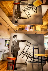 Professional portrait of Romário, the founder of móveis e cia, standing in his woodworking shop surrounded by wooden furniture.