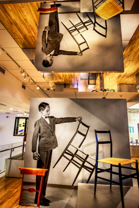 Professional portrait of Romário, the founder of móveis e cia, standing in his woodworking shop surrounded by wooden furniture.