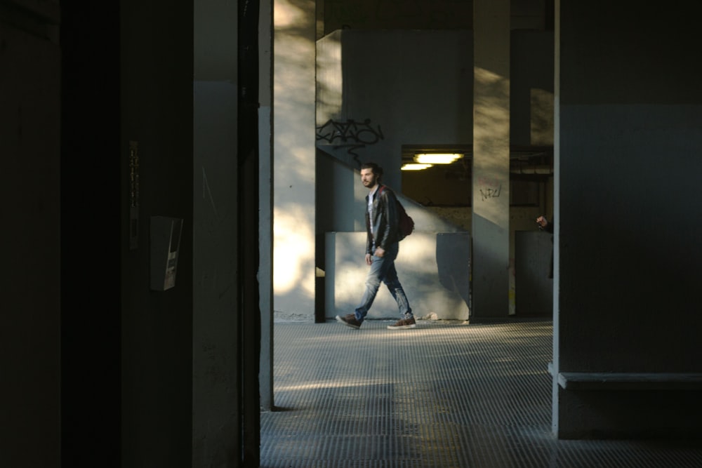 a man walking down a hallway in a building