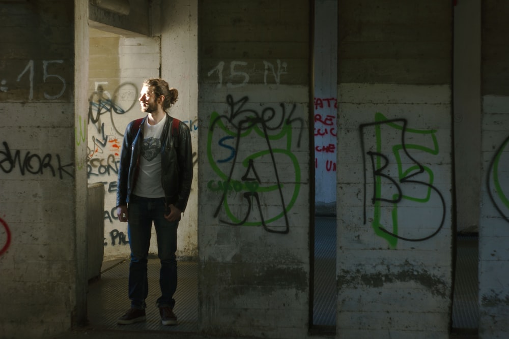 a person standing in a room with graffiti on the walls