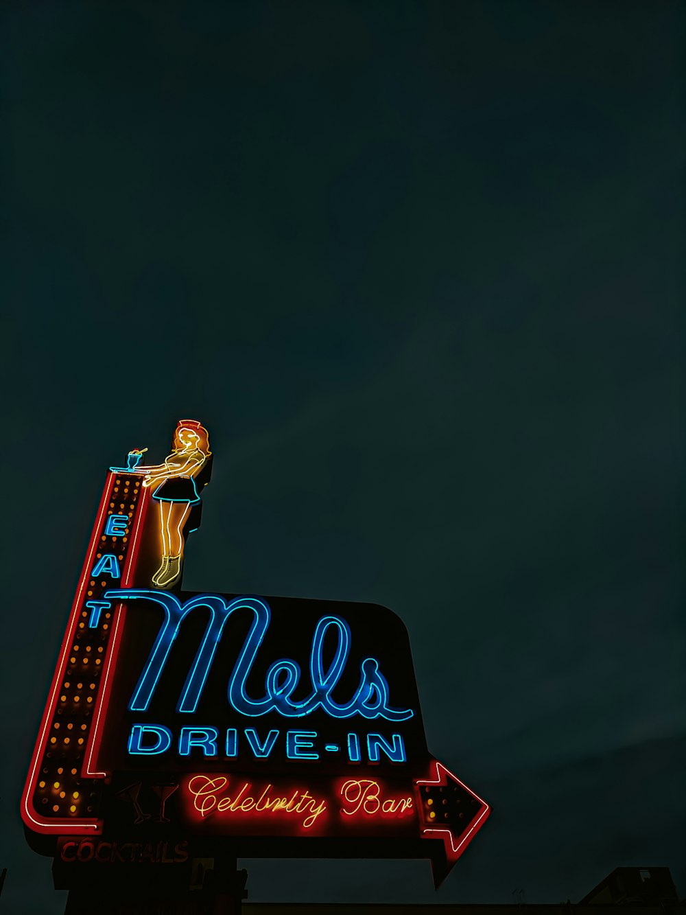 Eine Leuchtreklame mit der Aufschrift Mels Drive - vor einem Gebäude