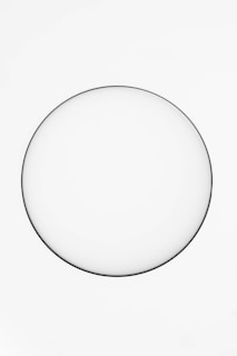 A minimalistic white plate sits against a plain white background, creating a simple and clean composition.