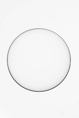 A minimalistic white plate sits against a plain white background, creating a simple and clean composition.