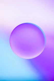 A glowing neon gradient sphere floating against a deep violet-to-black background with subtle glassmorphism blur.