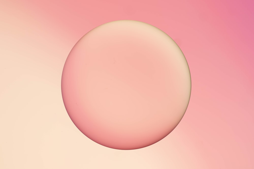 a pink and yellow background with a round object in the middle