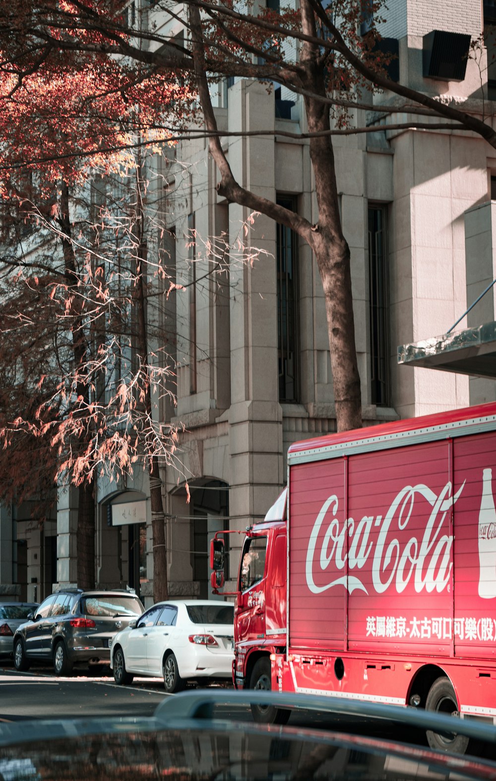 a coca - cola truck parked on the side of the road
