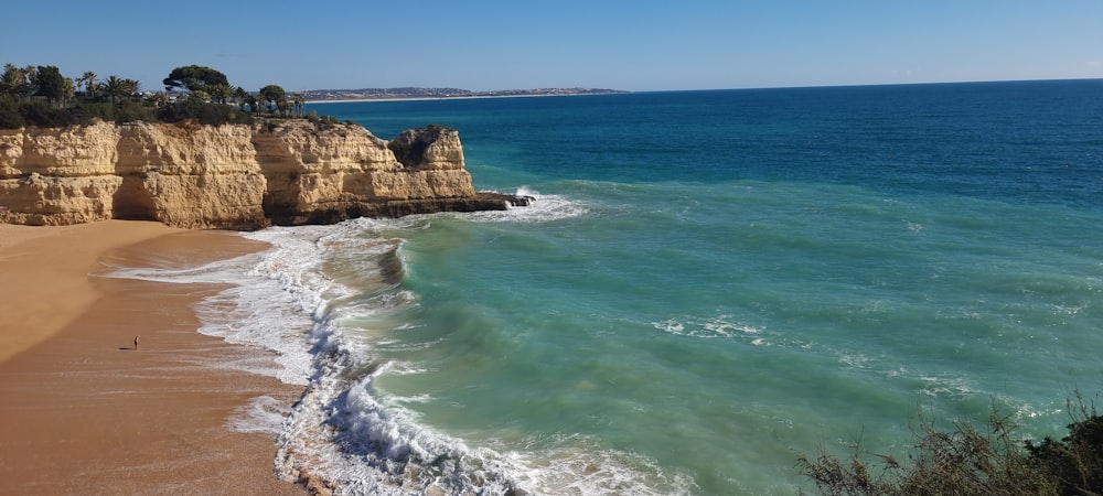 a view of a beach with a cliff in the background