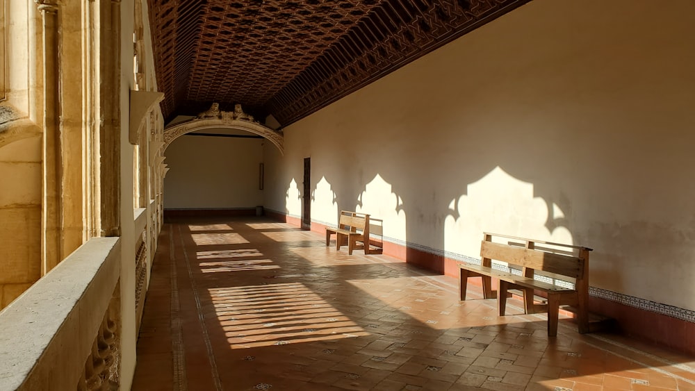 a long hallway with benches and a ceiling