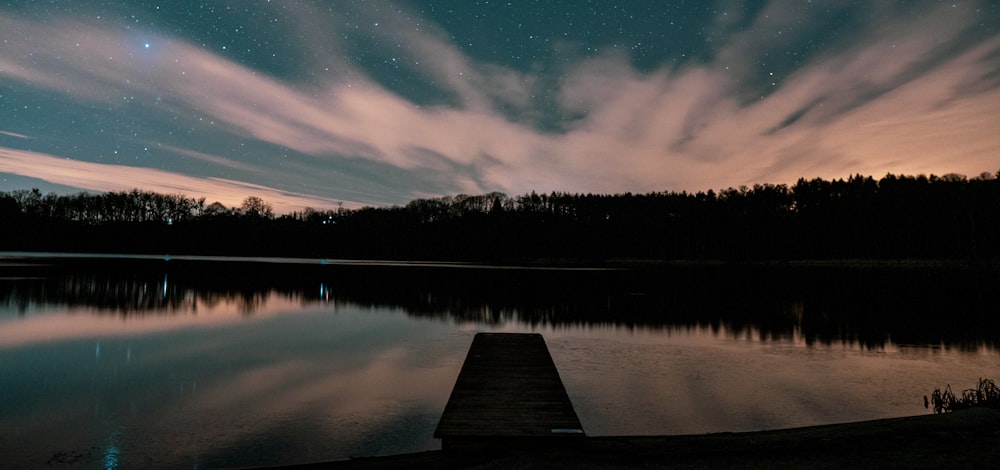a dock on a lake under a night sky