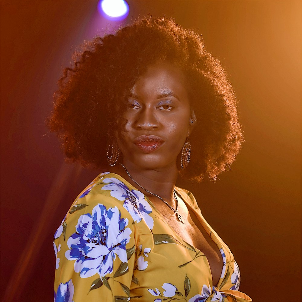 a woman with an afro standing in front of a spotlight