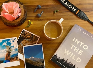 a wooden table topped with pictures and a cup of coffee