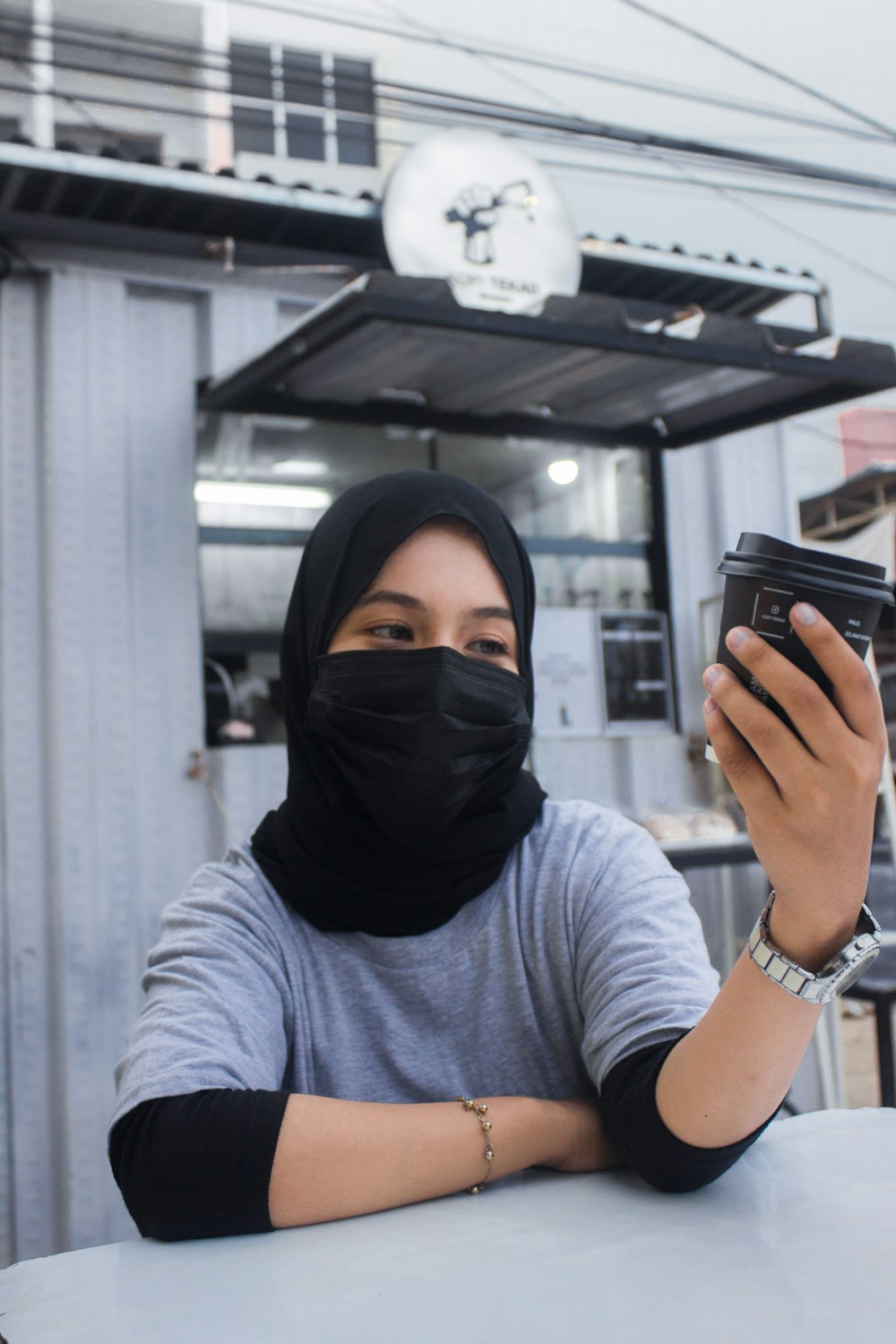 a woman sitting at a table with a cell phone