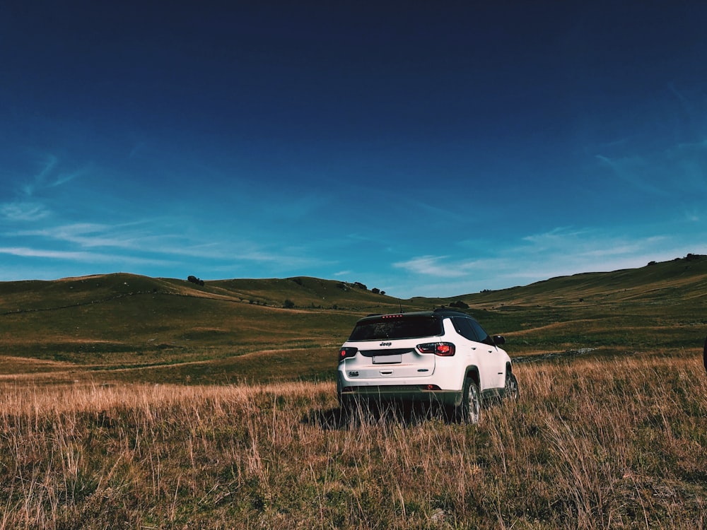 a white car is parked in a field