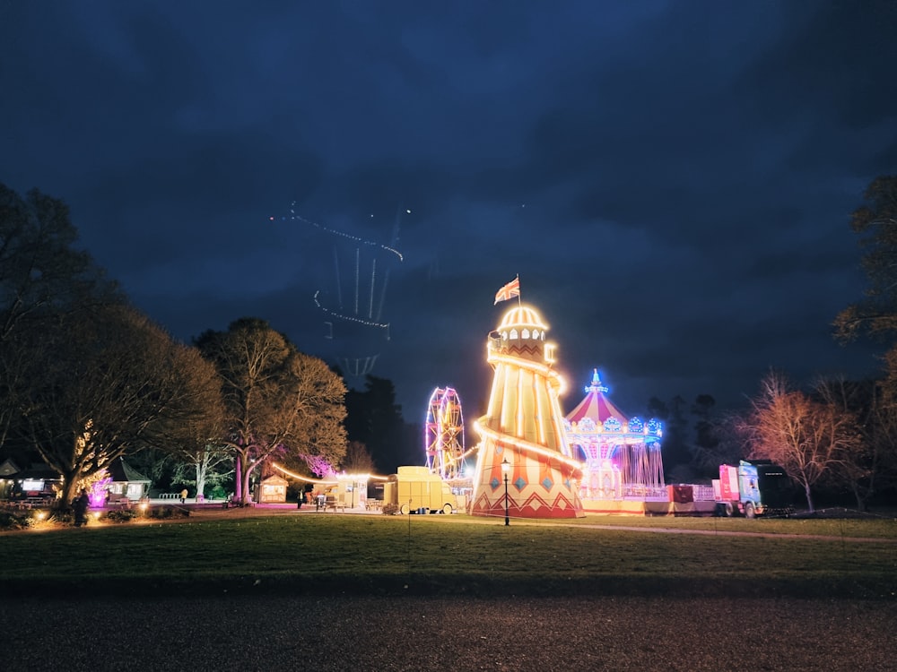 a large building lit up at night in a park