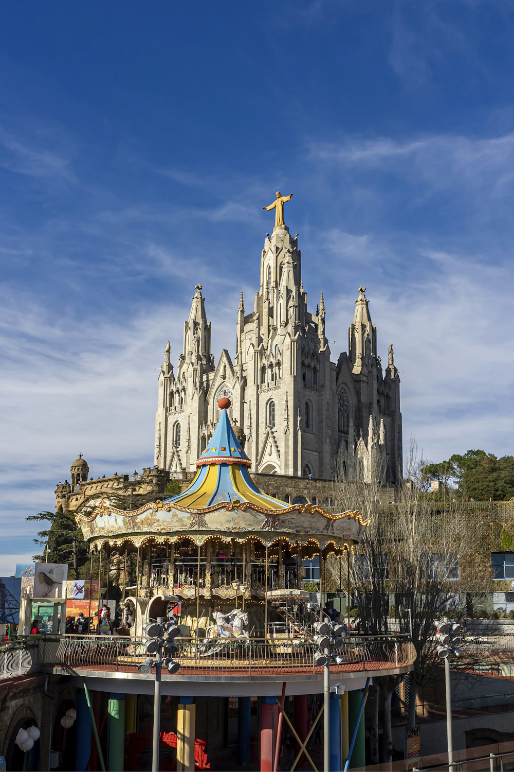 a carousel in front of a castle with a cross on top