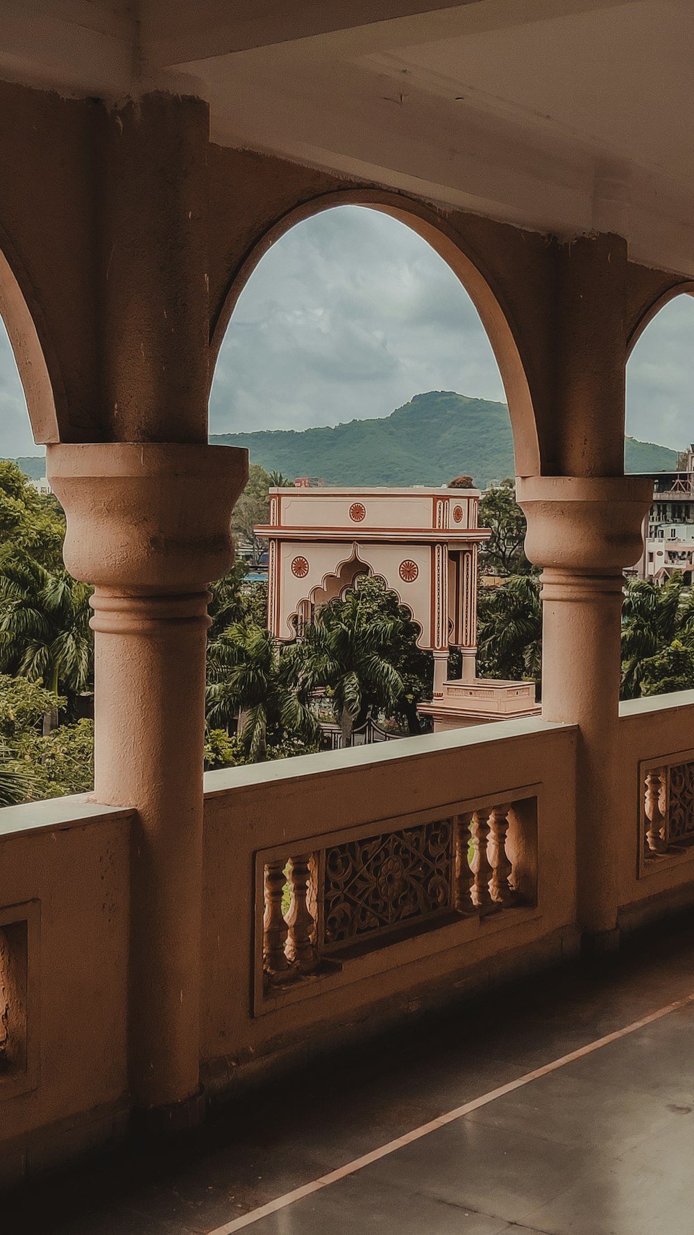 a balcony with arches and a view of a city