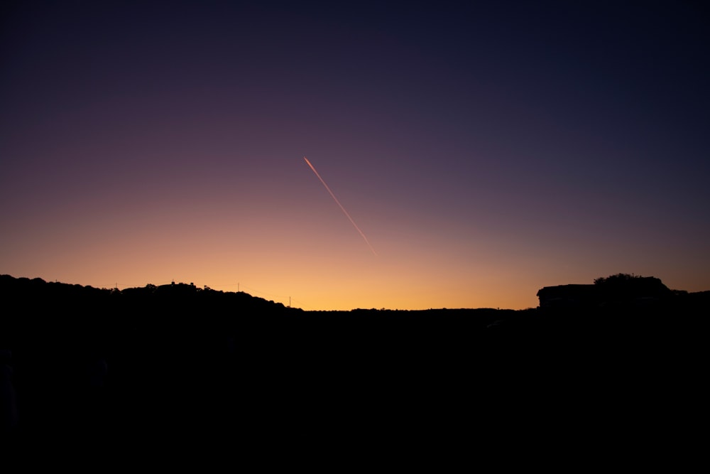 Ein Flugzeug fliegt bei Sonnenuntergang am Himmel