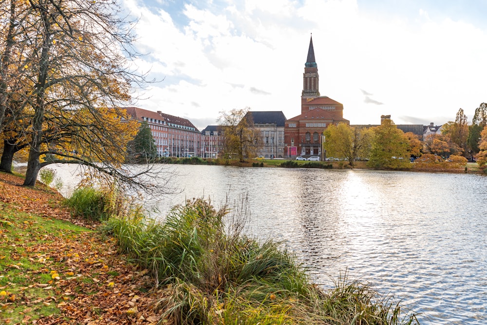 a lake in front of a building with a clock tower