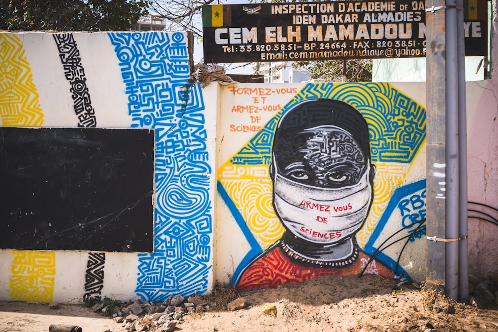 a wall with a painting of a woman wearing a mask