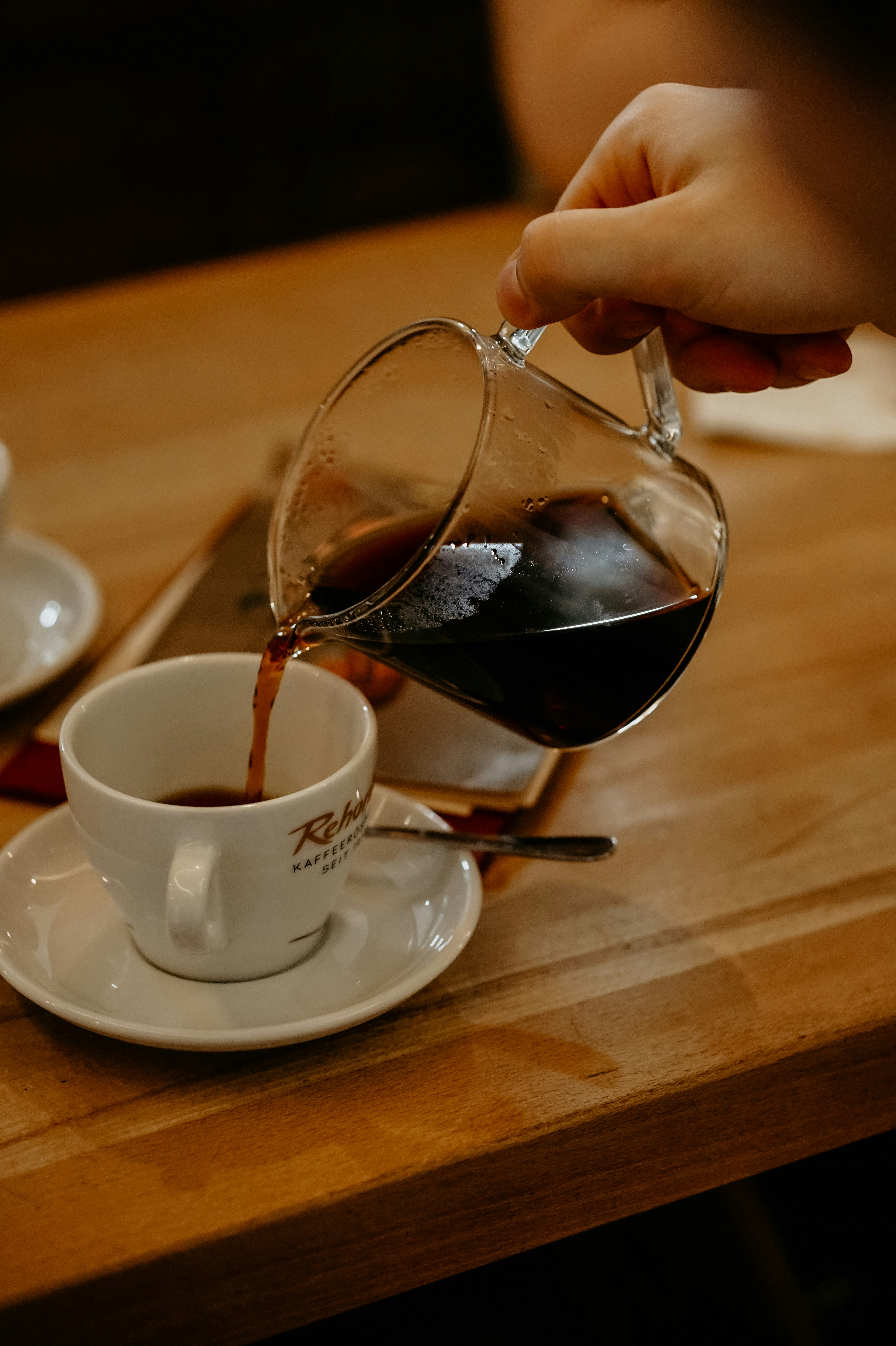 Eine Person gießt Kaffee in eine Tasse