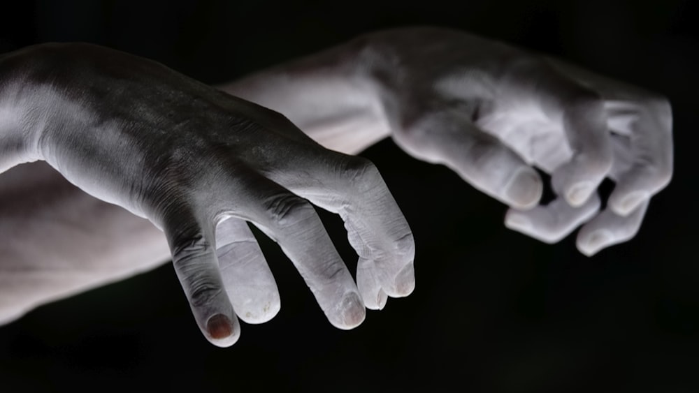 a close up of a person's hands with white paint