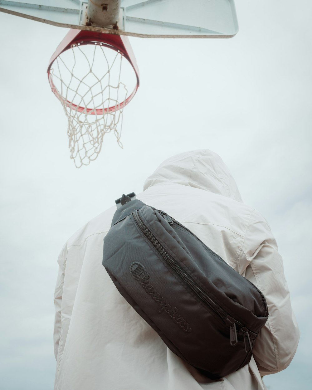 a man in a white jacket is holding a black bag