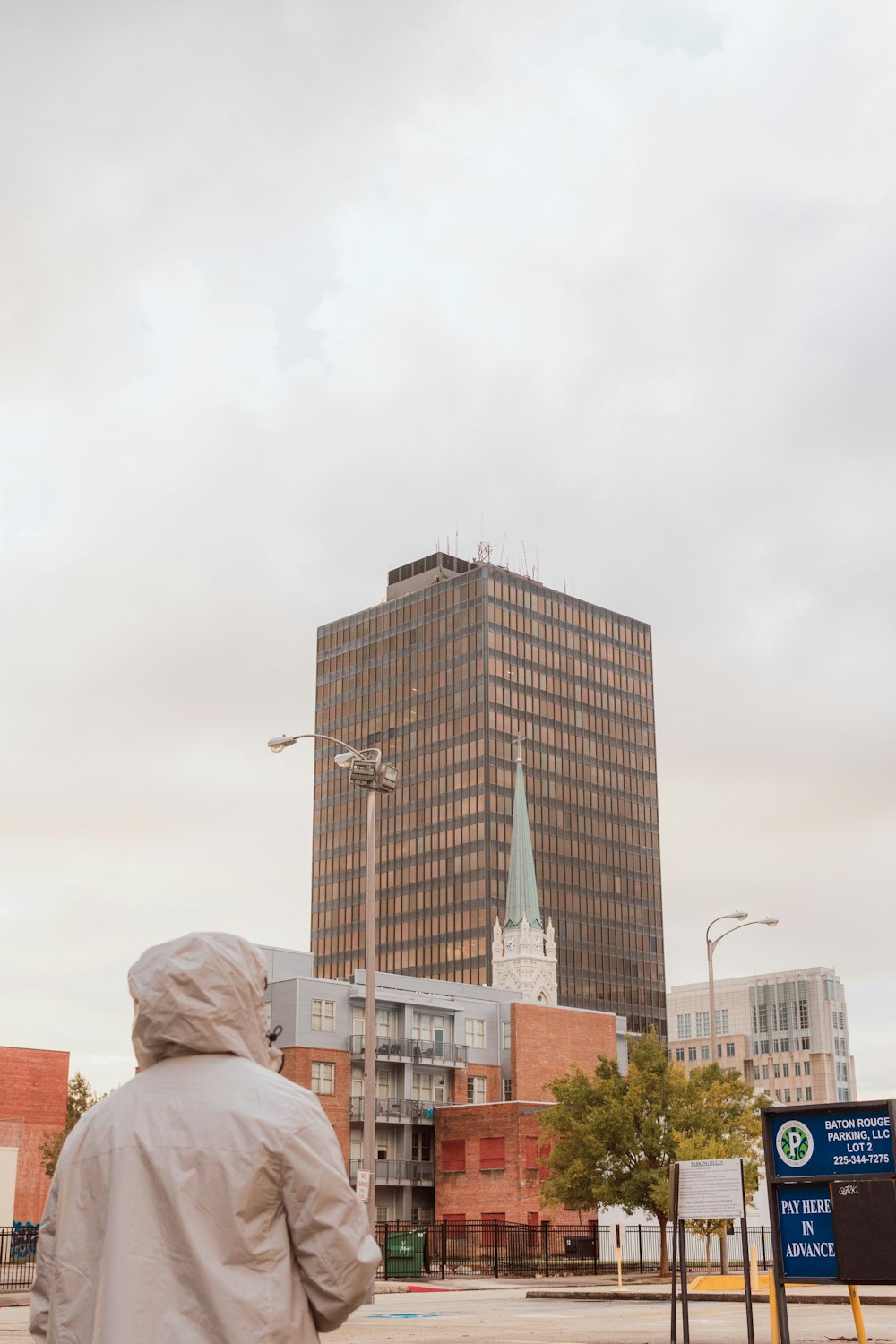 고층 건물 앞에 서있는 사람