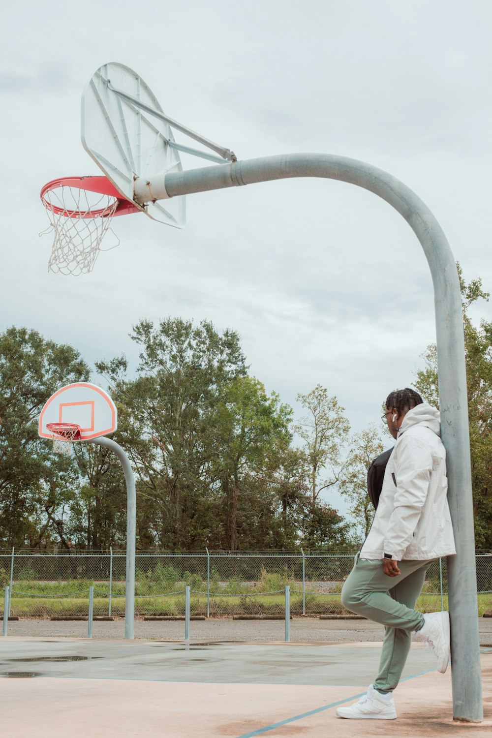 a man standing on a basketball court next to a basketball hoop